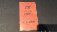 Brown cover of the stamp book with 'Hygrade Handfile for Stamp Blocks' title and handwritten '64 - 79'