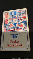 Cover of the white pocket stock book with vintage USA stamp illustrations and an eagle emblem