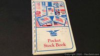 Photo of cover of the pocket stock book decorated with American flag-themed postage stamp images and handwritten notes indicating USA stamps 3c to 5c.
