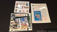 Photo showing multiple commemorative stamp sheets including Looney Tunes 2001 and 2000 commemorative yearbook in unopened packaging.
