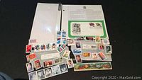 Photo showing the complete arrangement of the postage stamps including the sealed Muppets Commemorative FDC set and various loose uncanceled stamps.