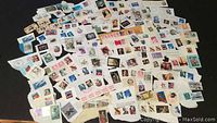 Photo of large assortment of canceled postage stamps on torn pieces of paper.