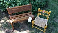 Wooden decorative bench and painted youth rush seat chair together outdoors on grass.