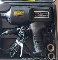 Full view of Chicago Electric impact wrench in case with power cord and three socket attachments.