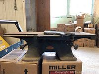 Side view of vintage Companion belt drive planer showing cast iron construction and table feeding surfaces.