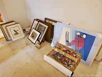 Overview of lot showing tapestry roll, posters, framed prints and mirror arranged on floor