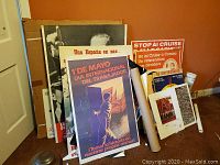 Wide view of pile of posters leaning against wall on carpet