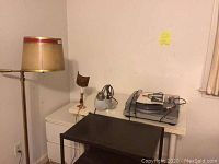 Wide view of the four items: floor lamp, small lamp, adjustable desk lamp, and Technics SLD1 turntable on white cabinet with black table in foreground