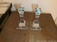 Pair of crystal Tiffany & Co candlesticks shown on a wooden surface.