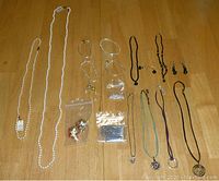 Full spread view of the lot on a wooden floor showing all bracelets, necklaces, earrings, and bead bags
