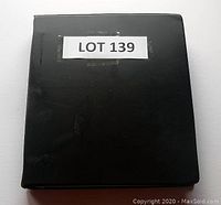 Closed front cover of black binder album containing the first day covers