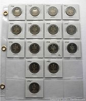 Plastic sheet with individual slots holding Canadian 50 cent coins from 1968 to 1982 arranged by year with some years missing, view of reverse sides with Canadian Coat of Arms