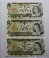 Front side of three consecutive 1973 Canadian one-dollar banknotes showing Queen Elizabeth II portrait and serial numbers EAR9713320, EAR9713321, EAR9713322.