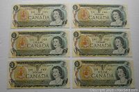 Front sides of six Canadian 1973 one dollar bills showing Queen Elizabeth II portrait and serial numbers A0566375J-O.