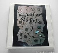 White binder album labeled 'Canadian Nickels' with 2x2 coin holders inside on the cover page