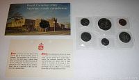 Photo of the original Royal Canadian Mint envelope with 1974 date and a card with bilingual text about coin circulation restrictions, accompanied by the sealed set of six coins.