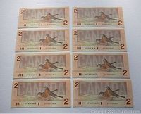 Eight consecutive 1986 Canadian $2 bills back side featuring robin bird design.