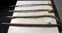 Four walking sticks laid flat on table; showing length and handle details