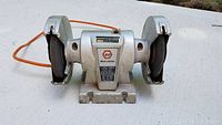 Front view of the Black & Decker 5 inch bench grinder showing both grinding wheels and power cord.