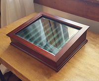 Top view of the closed mahogany wood display case with glass top reflecting window.