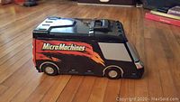 Side angle photo of the black plastic Micro Machines folding van playset showing flame decals.