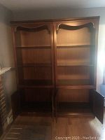 Two cherry wood Thomasville bookcases side by side with cabinet doors open showing inside shelving