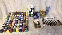 Full view of the craft paints, nail polishes, rope twine, mini glue gun and glue sticks, and decorative sign on a beige background