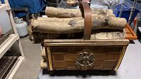 Photo showing the entire basket filled with birch logs and the wooden woven structure with metal accents.