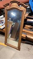 Full length view of the rectangular wooden framed wall mirror showing overall shape, wood grain finish, and reflective surface.