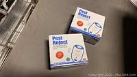 Two boxes of Pest Reject Ultrasonic Pest Repellent devices with clear product name and branding visible.