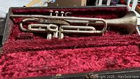 Full trumpet inside case showing wear of case interior and trumpet tarnish