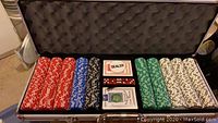 Full open poker chip set showing various colored clay chips and playing cards in the center