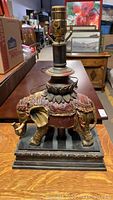 Front view of the detailed elephant base lamp with visible ornate texture and decorative paint.