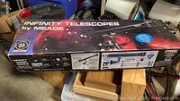 View of Meade Infinity Telescope box showing product name and image of telescope.