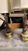 Pair of vintage brass and stone table lamps with cream fabric shades. One shade shows slight damage.