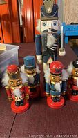 Group of five wooden nutcrackers, one large and four smaller, showing front detail and colors