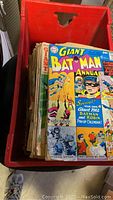 Crate filled with assorted vintage comic books, showing the 1962 Giant Batman Annual comic on top.