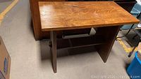 Overview photo of vintage wooden trestle table showing flat rectangular top and base structure with stretcher shelf.