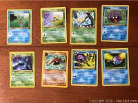 Photo showing eight different first edition Pokémon cards including Horsea, Bellsprout, Weedle, Shellder, Golbat, Kabuto, Tentacruel, Tentacool arranged on a flat surface.
