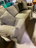 Overview of the three-seat sofa showing upholstery, cushions and armrest detail