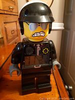 Front view of the LEGO Movie Bad Cop minifigure clock showing digital LCD display on torso and the character's distinct expression and helmet.