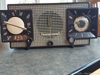 Wide photo showing the front of the vintage Zenith tube radio with clock and General Electric transistor radio before description.