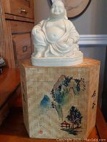 Photo of Buddha figurine seated on the decorative art box showing the overall look and scale of both items.