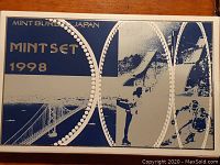 Front of the 1998 Japan Mint Set box showing blue and white design with athletic imagery and 'Mint Set 1998' text.