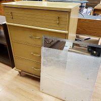 Overall front view of the 4-drawer highboy with a separate beveled mirror leaning against it.