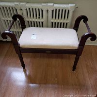 Front view of the wood bench showing upholstered seat and armrests.