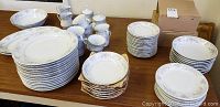 Full set including dinner plates, smaller plates, bowls, cups, creamers, sugar bowls, and serving dishes arranged on a table.