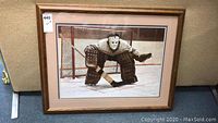 Front view of framed print showing hockey goalie in gear in front of net.