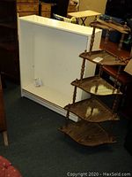 White rectangular bookshelf with adjustable shelves, empty, placed on carpeted floor.