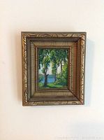 Frontal view of the miniature landscape painting in ornate carved gilt frame
